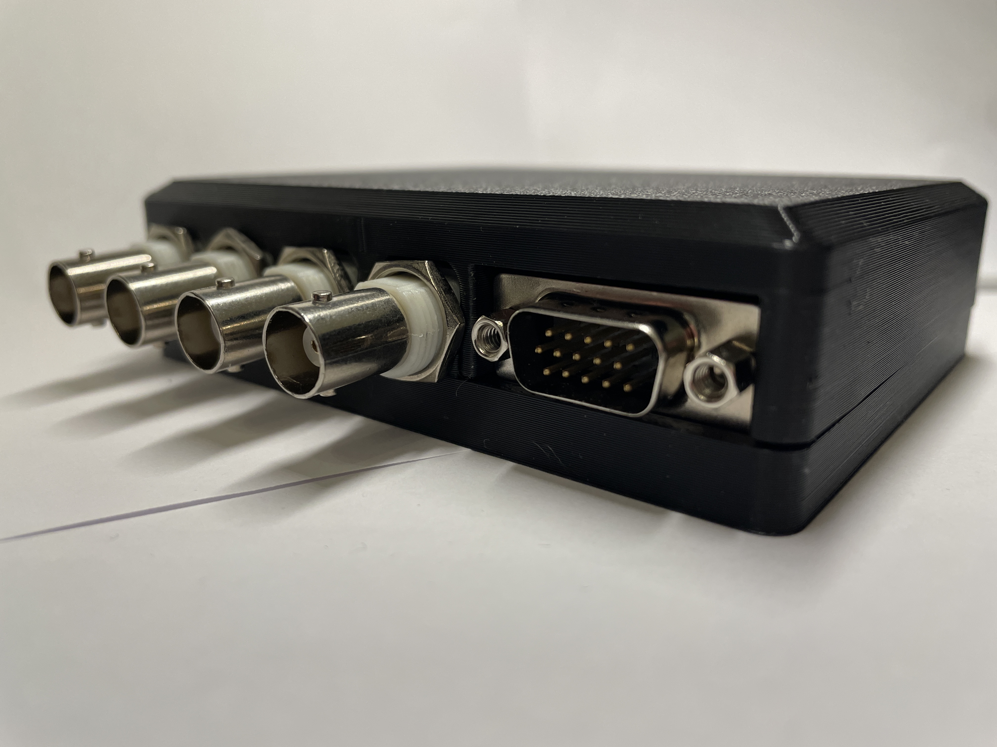 Black box with 4 BNC outputs and a HD-15 port.